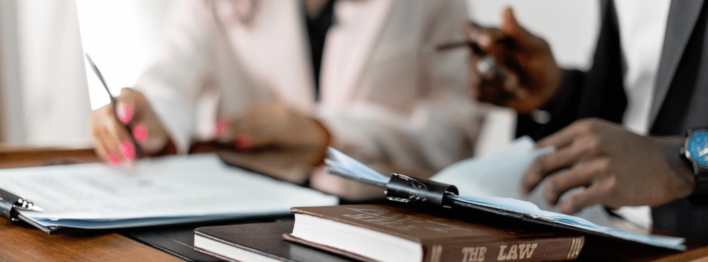 Two attorneys reviewing legal paperwork at a desk with a visible law book, representing how law firms can present a professional image on Instagram.