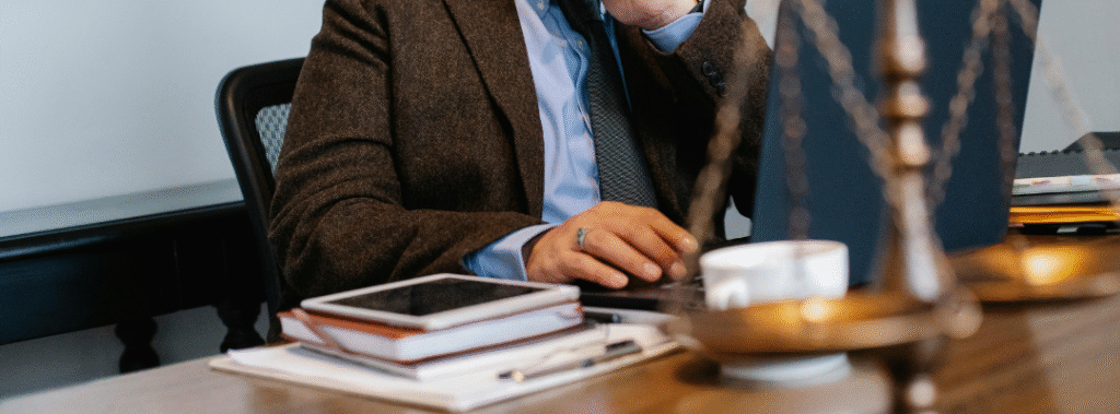 Attorney on the phone at a desk with laptop and legal scales, a visual example of professional law firm branding.