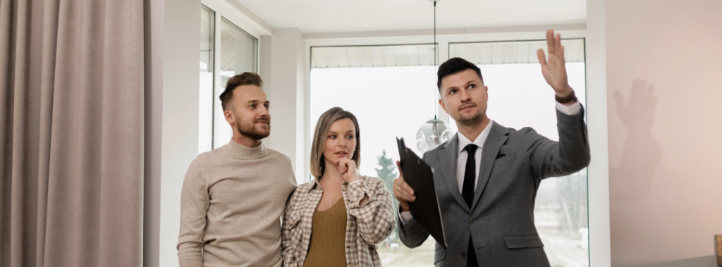 Realtor showing a modern home to a couple, representing custom real estate marketing materials that help agents stand out.