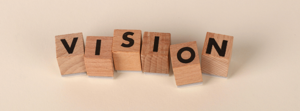 Wooden blocks spelling “Vision” on a neutral background, concept for brand strategy vs visual identity.