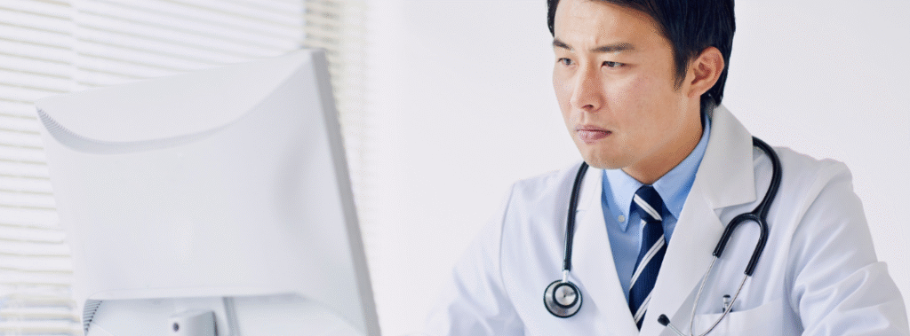 Doctor using a desktop computer in a bright clinic, example of healthcare website accessibility in practice.