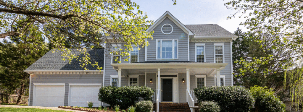 Front exterior of a two story home with porch and two car garage, example property for open house marketing templates.