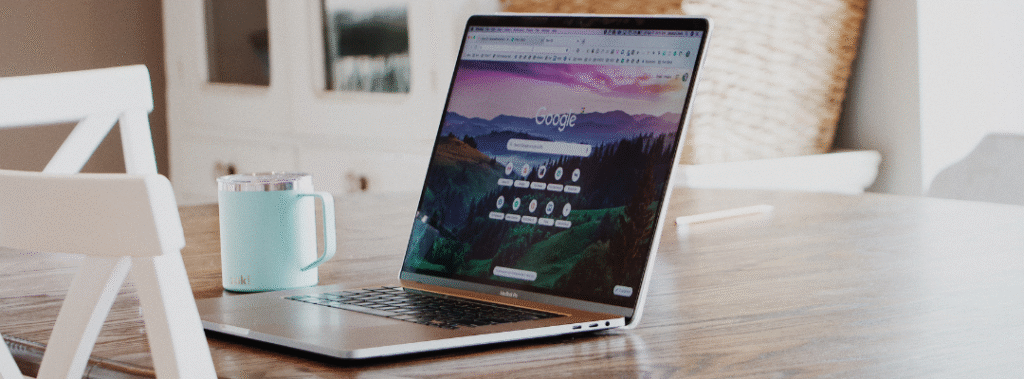 Open laptop on a wooden table displaying a browser, research for real estate landing pages.