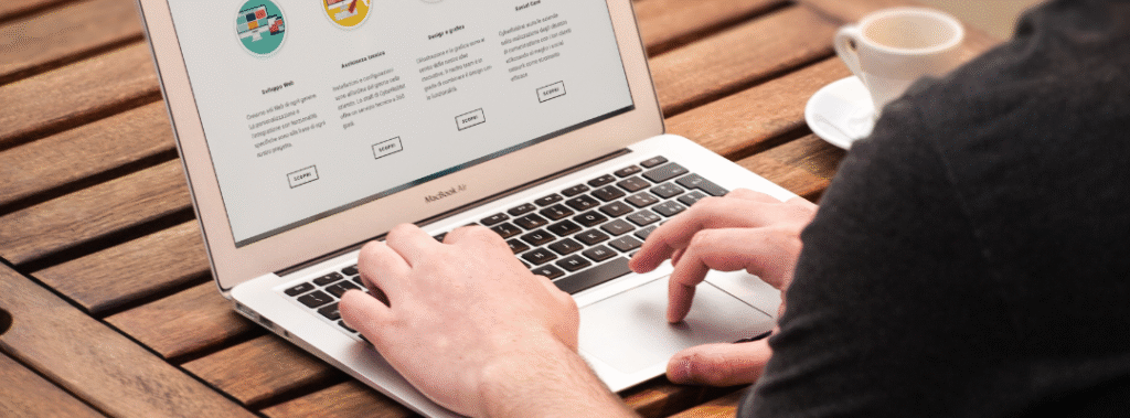 Person viewing a laptop with service summaries and buttons, example of services page design that guides visitors to act.