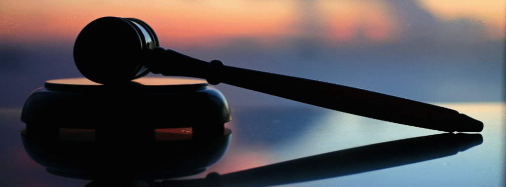 Gavel on a reflective desk at sunrise, visual for a law firm website homepage.