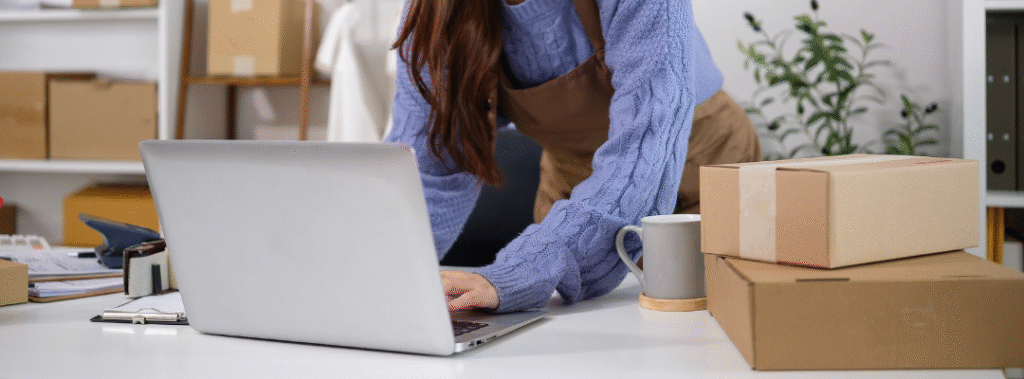 A business owner works on packaging orders, illustrating the importance of paying attention to Sacramento e-commerce tips.